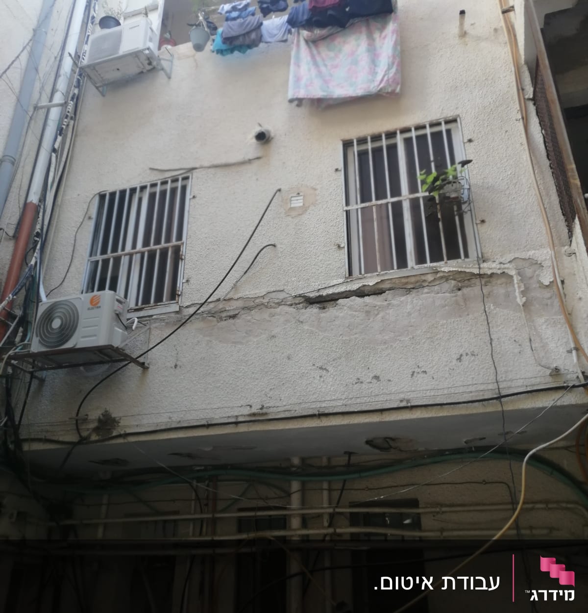 קיר עם סדקים ותשתיות חשופות